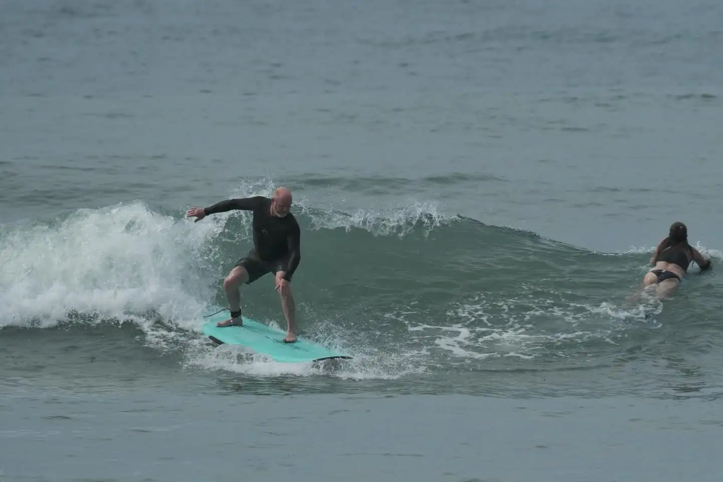 Surfer riding a wave during a lesson for all ages
