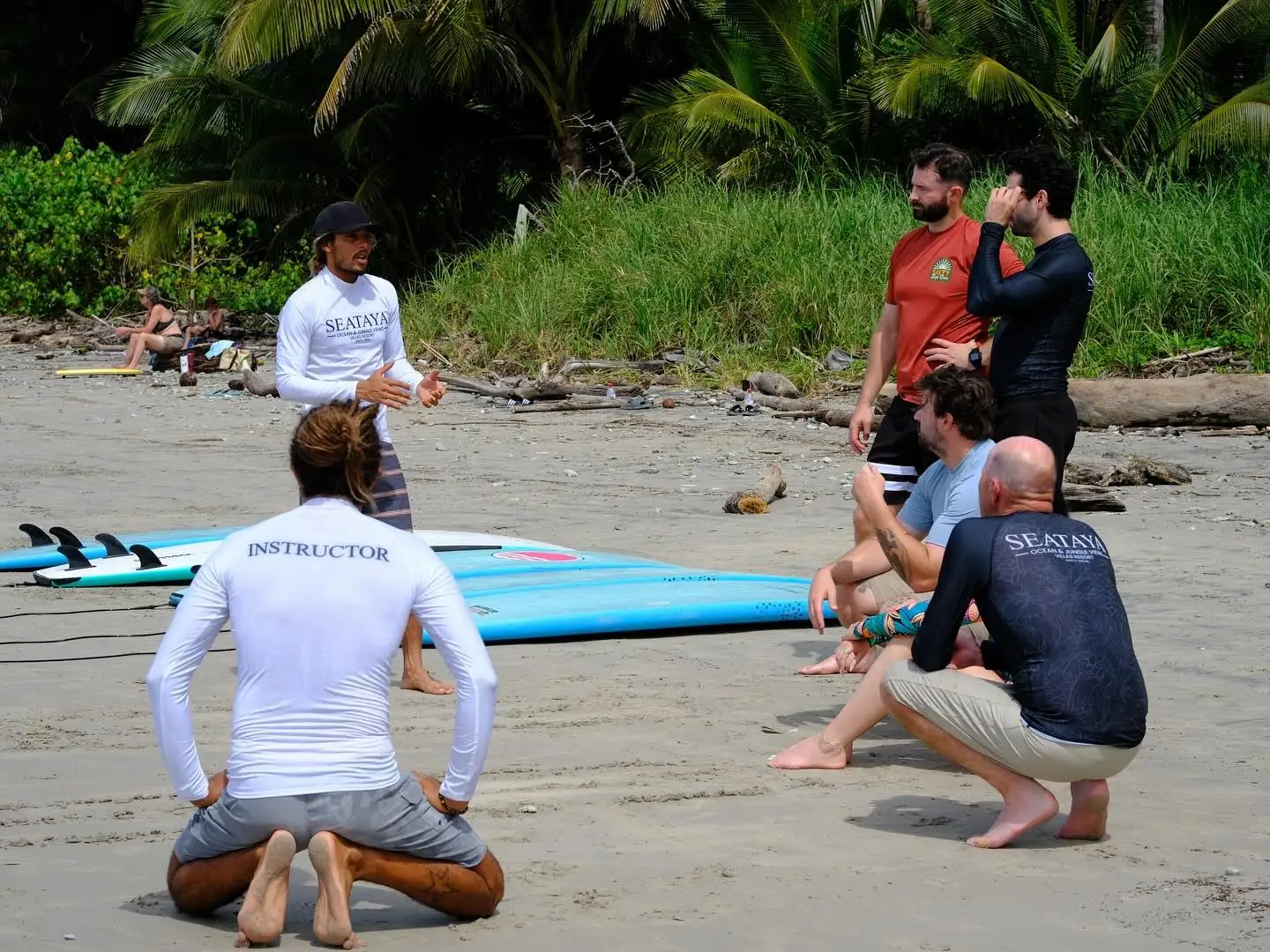 Certified surf instructor teaching a beach lesson to a group in Santa Teresa
